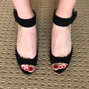 Black open toed heels with ankle strap.